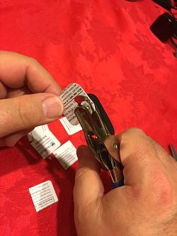 image of using a hole punch to poke a hole in a piece of an ID card